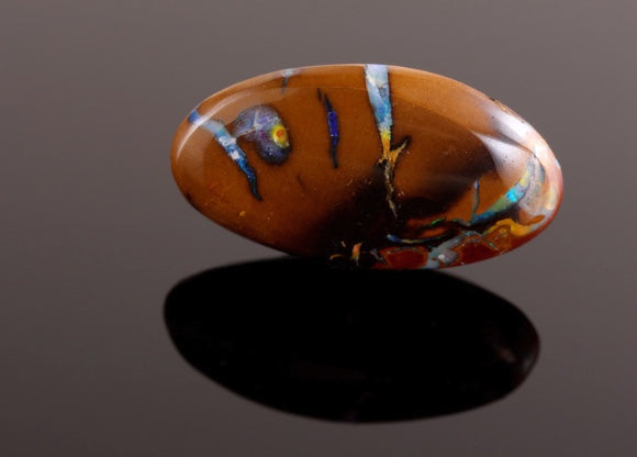 Polished brown Opal with vibrant colorful inclusions from Queensland Boulder Opal.