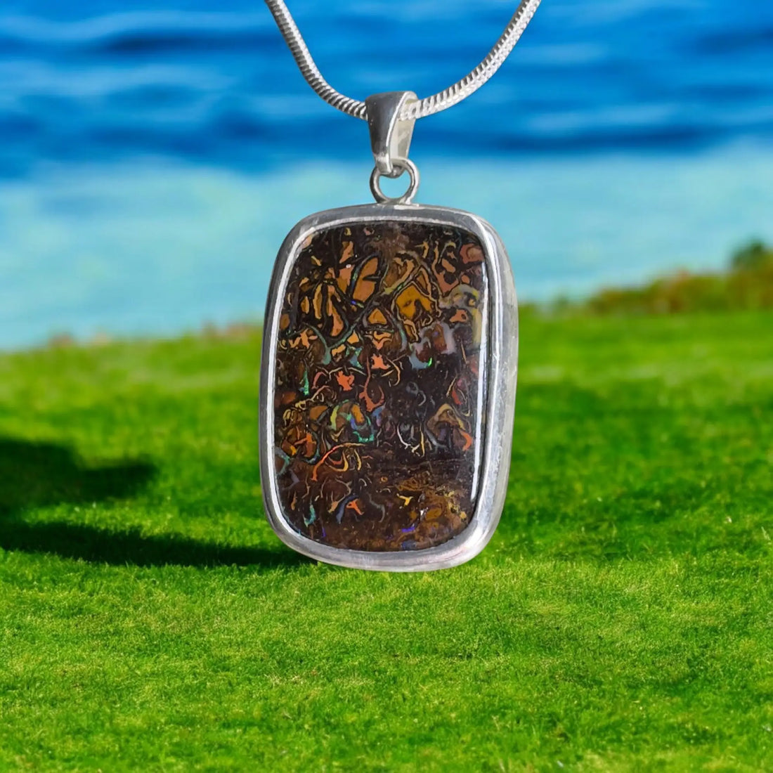 Rectangular silver pendant featuring a vibrant mosaic Australian Boulder Opal stone