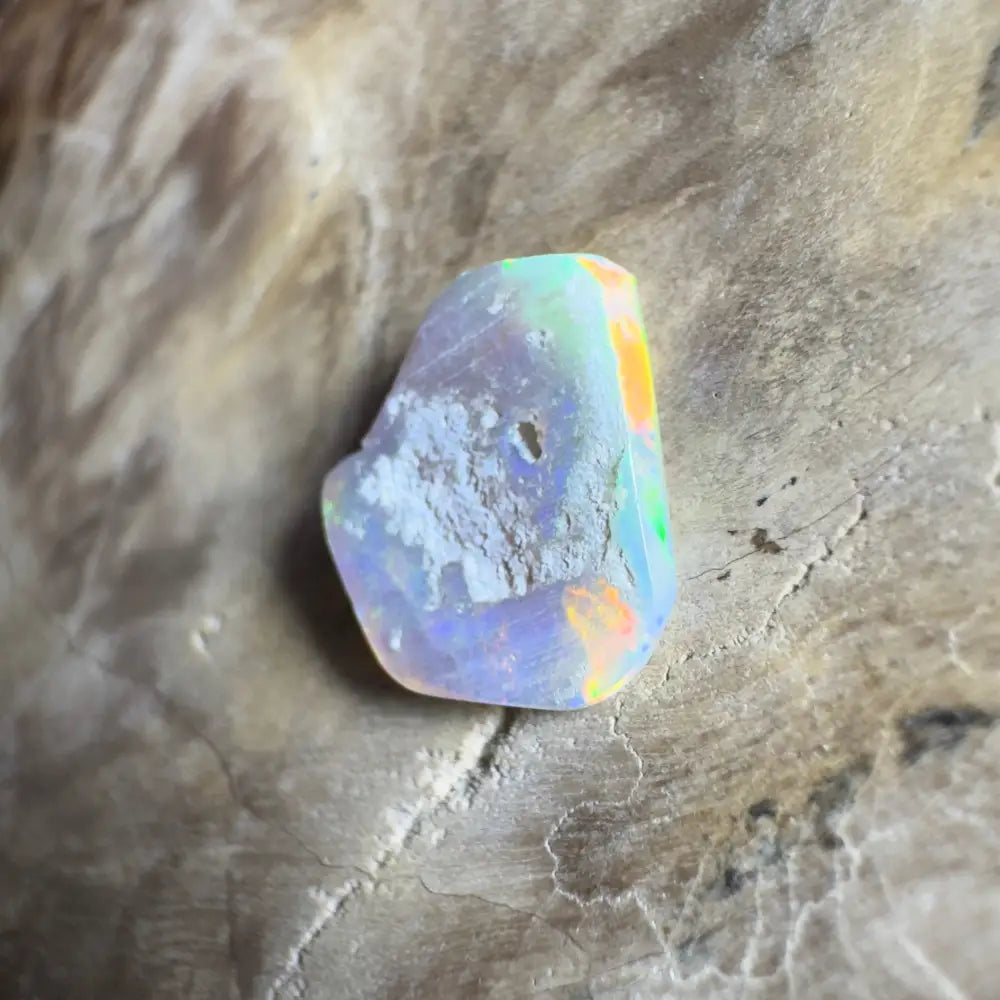 Iridescent opal gemstone with rough edges.