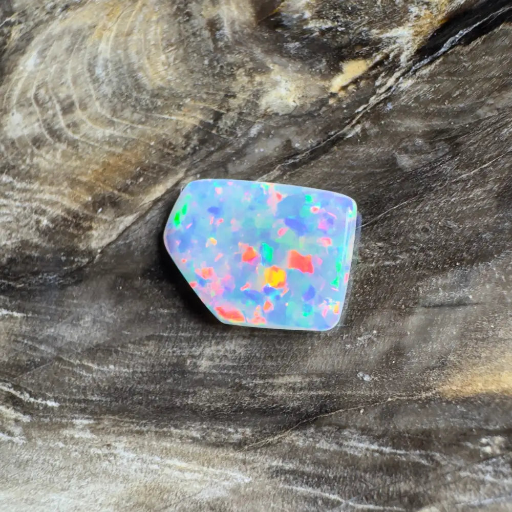 Irregularly shaped opal with colorful flecks.