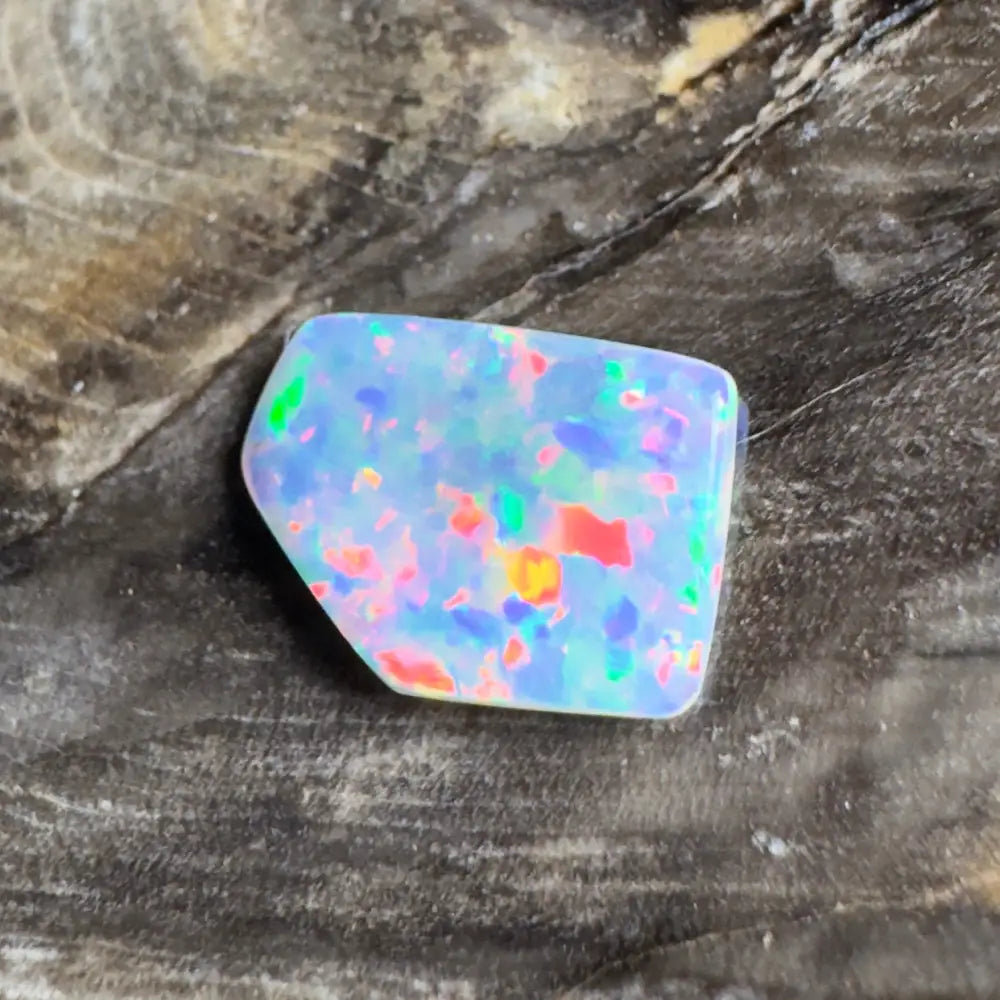Irregularly shaped opal with colorful flecks.