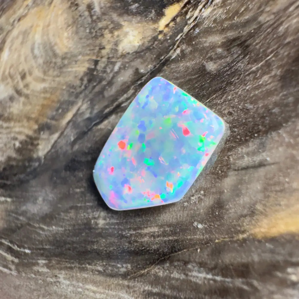 Irregularly shaped opal with multicolored flecks.