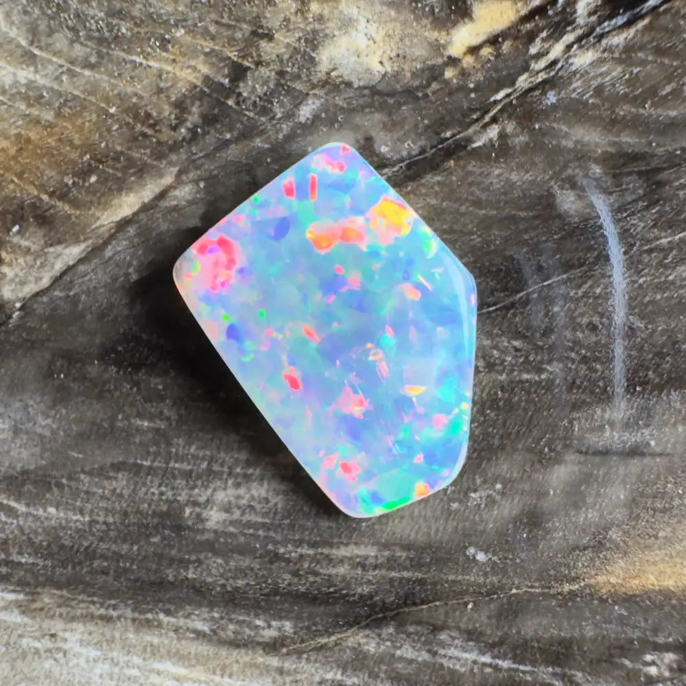 Irregularly shaped opal with multicolored flecks.