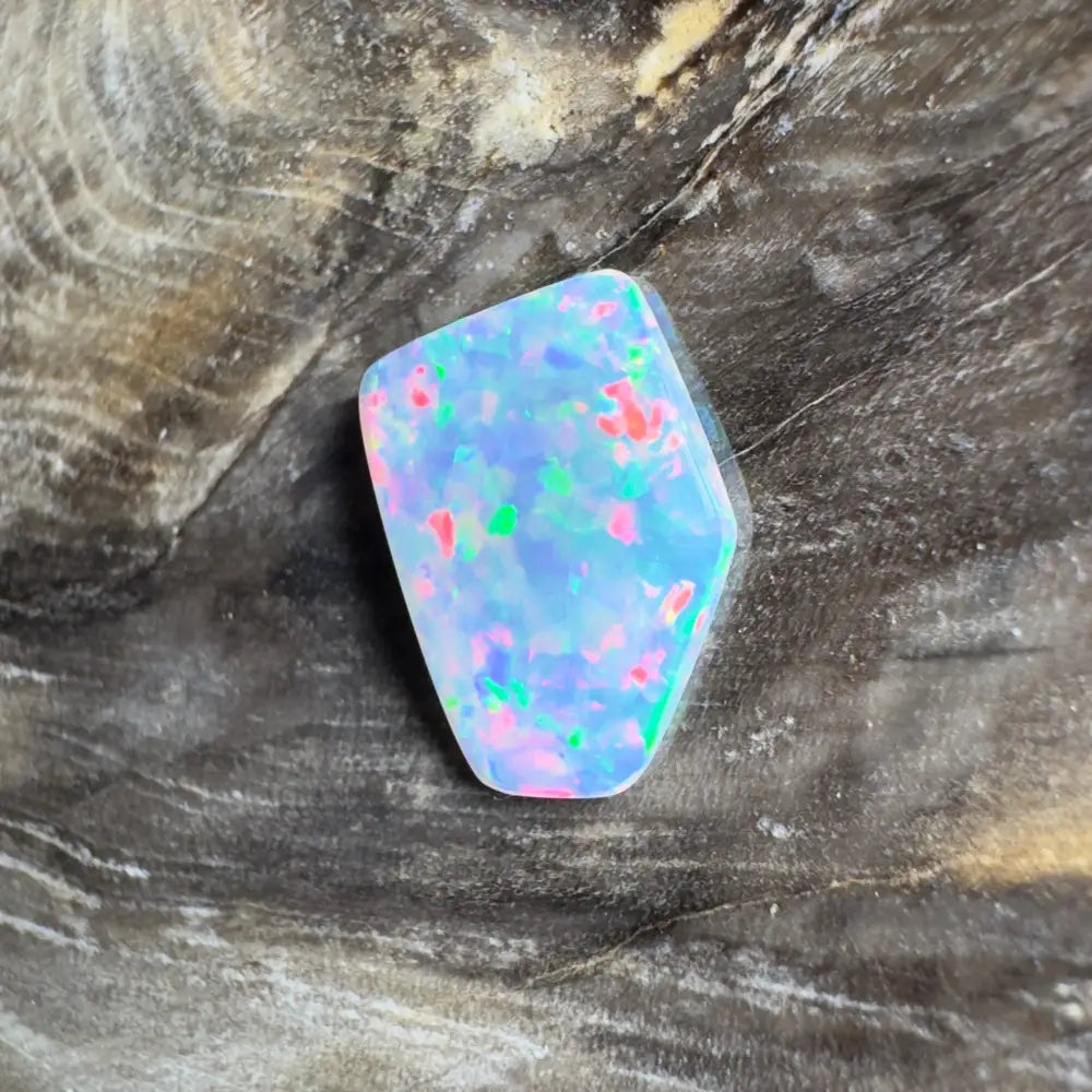 Irregularly shaped opal with blue, pink, and green flashes.
