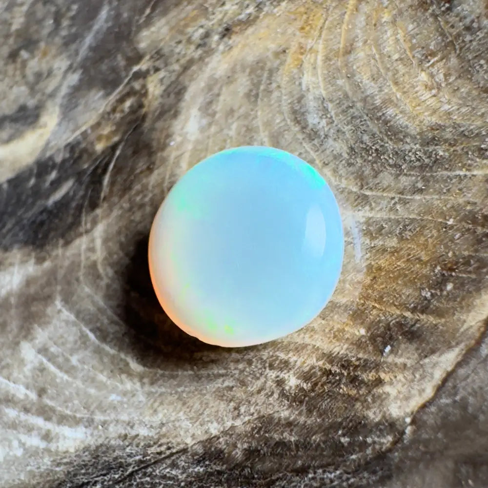 Opalescent, round gemstone.
