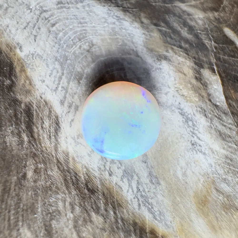 Round opal with blue and orange iridescence.