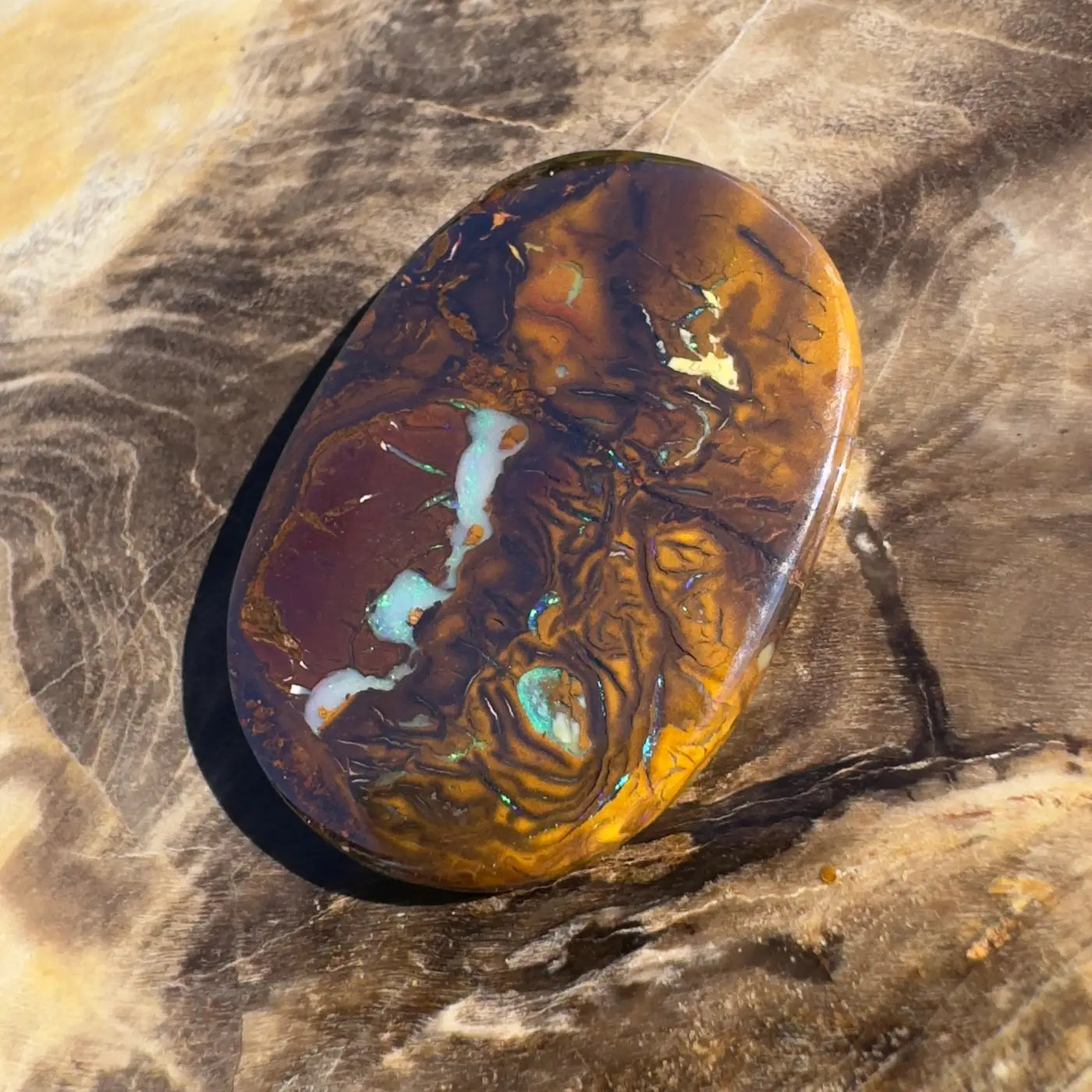 Polished Boulder Opal exhibiting brown and blue play-of-color in 15.9CT hand-cut solid piece