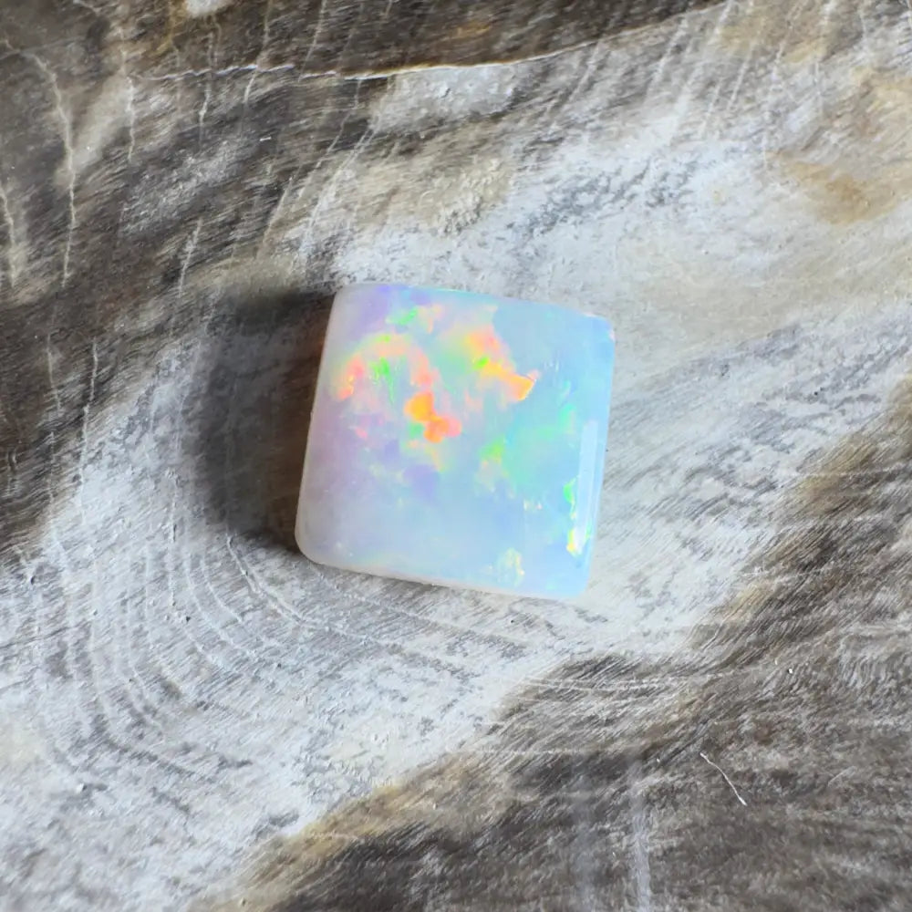 Square opal gemstone with iridescent colors.