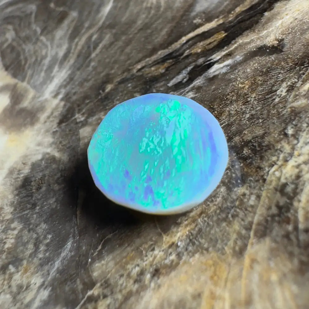Iridescent blue-green opal cabochon.