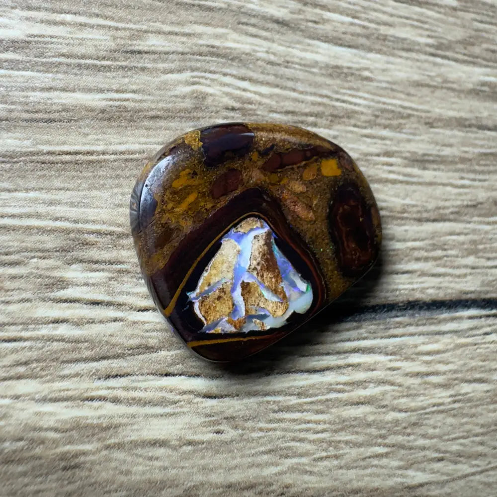 Polished boulder opal cabochon from Queensland displayed in 21.9ct hand-cut boulder opal with pipes