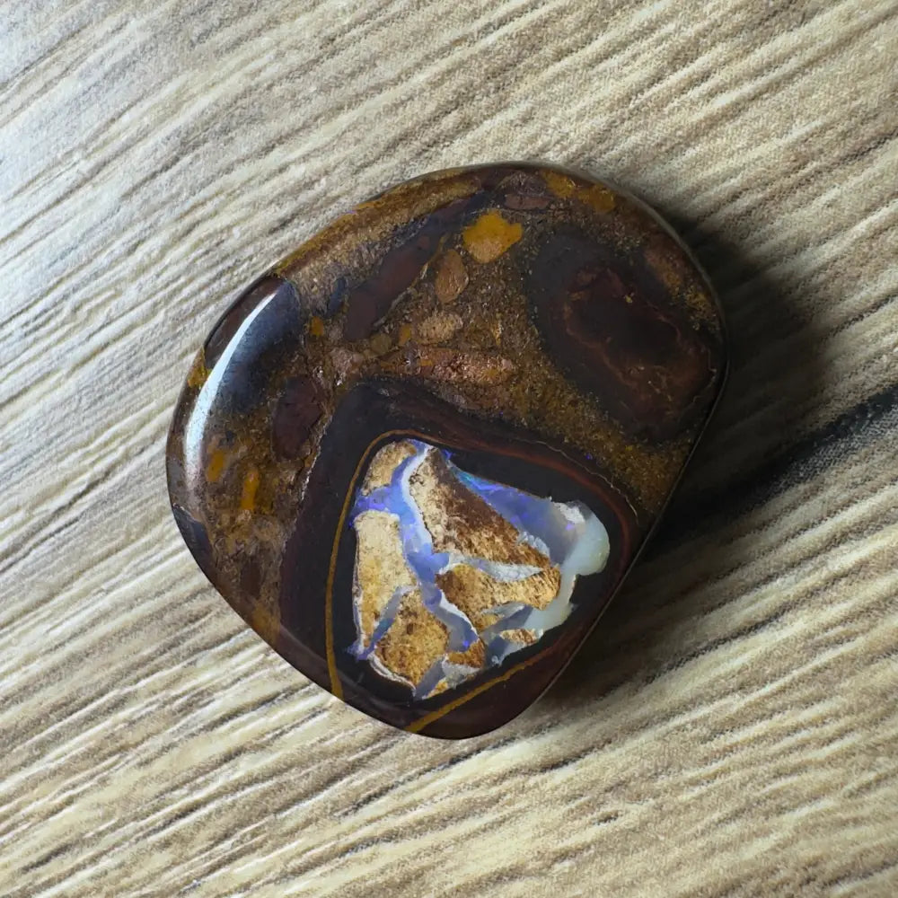 Polished 21.9 carat Hand-cut Queensland Boulder Opal with blue and gold inclusions