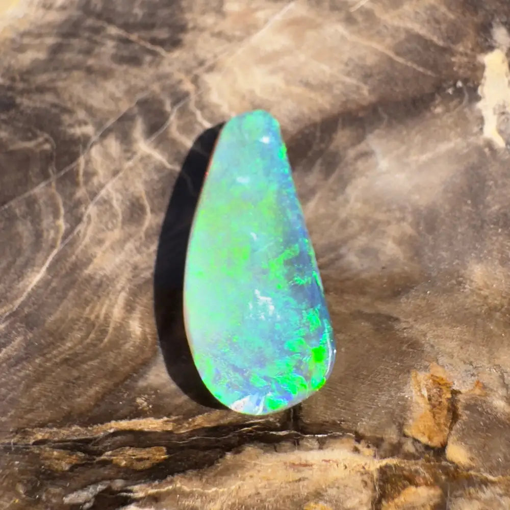 Teardrop-shaped opal with green and blue iridescence.