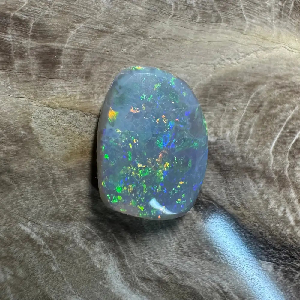 Iridescent opal gemstone from Lightning Ridge in a 3.2 carat hand-cut semi black opal display