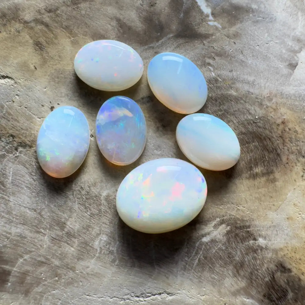 Six iridescent opal gemstones.