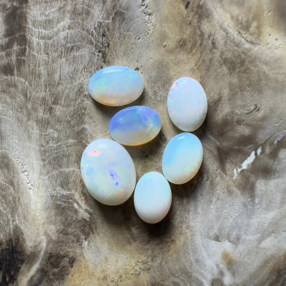 Six oval opals with iridescent play-of-color.