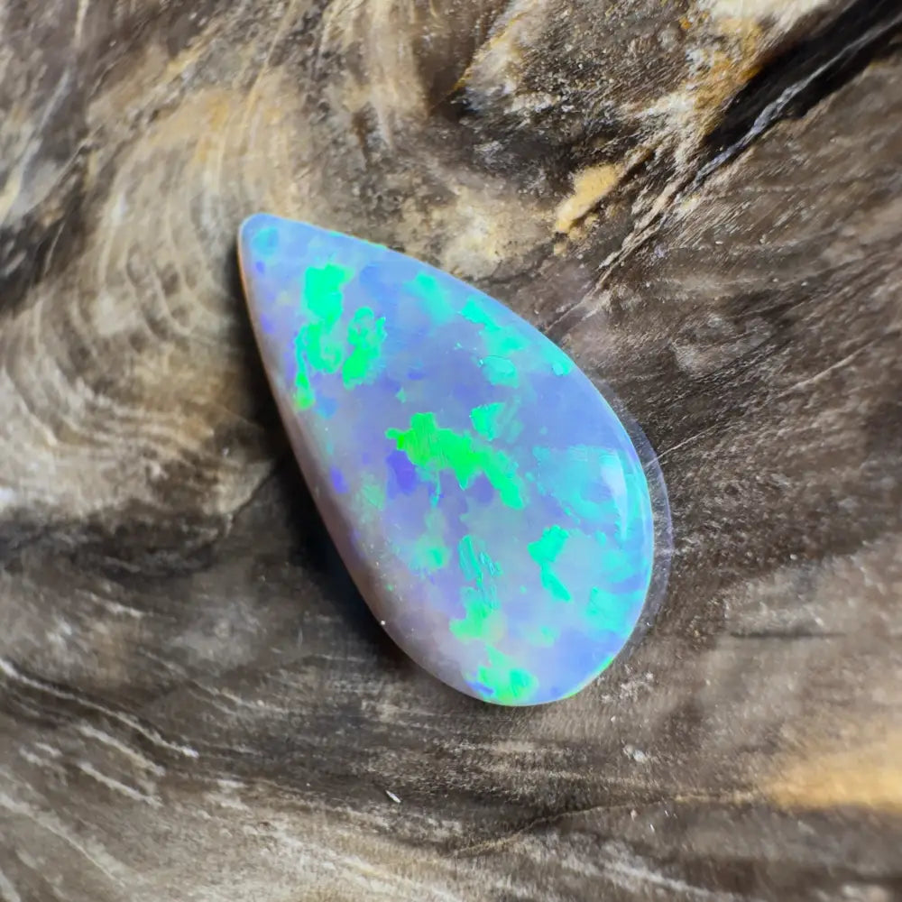 Teardrop-shaped opal with green and blue flashes.