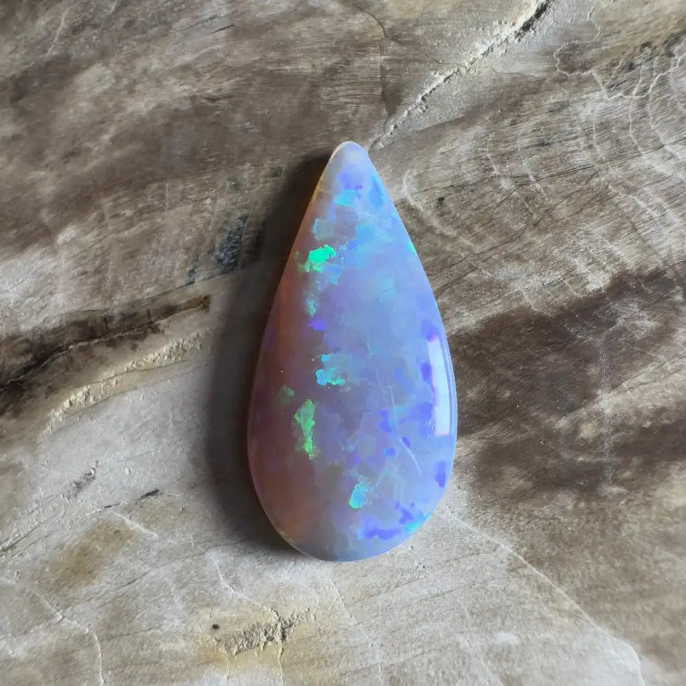 Teardrop-shaped opal with blue and green flashes.