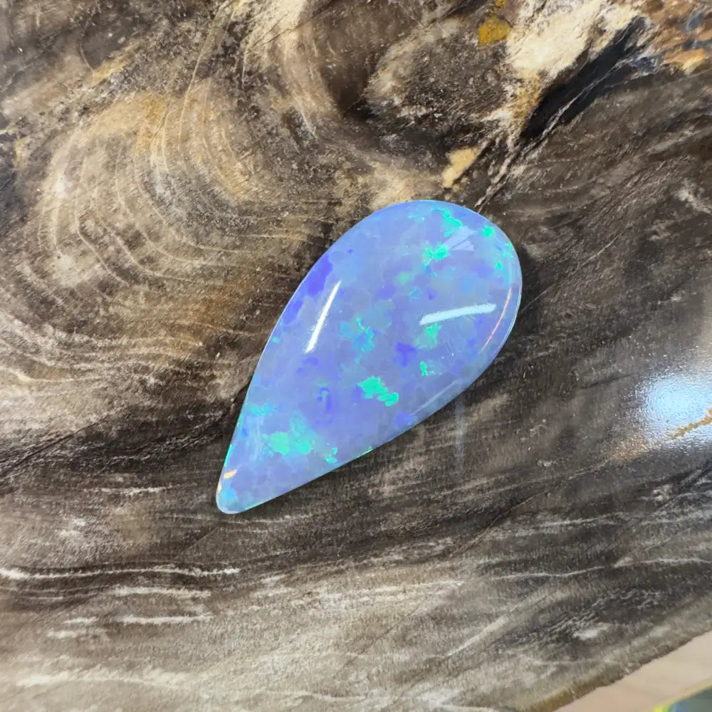 Teardrop-shaped opal with blue and green play-of-color.