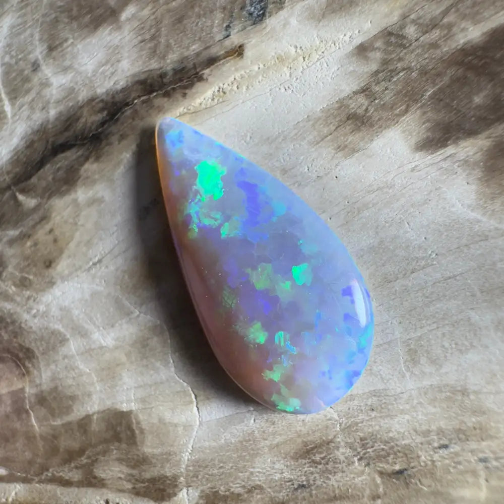 Teardrop-shaped opal with iridescent color play.