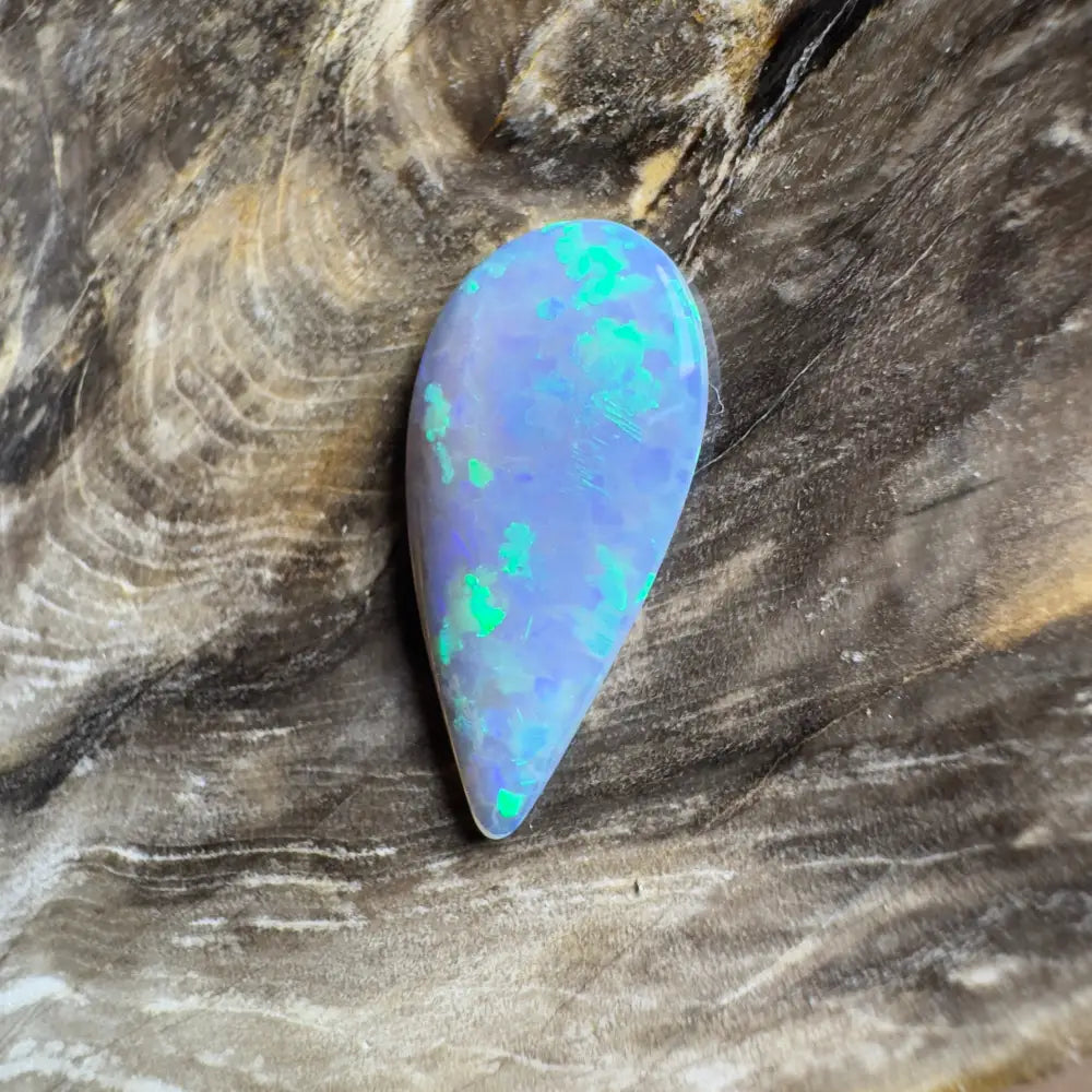 Teardrop-shaped opal with blue base and green flashes.