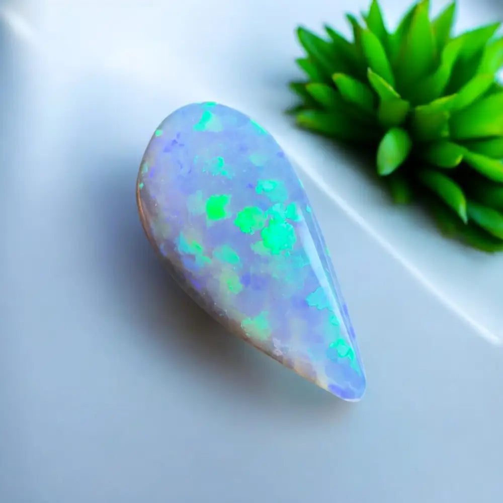 Teardrop-shaped opal with green and blue flashes.