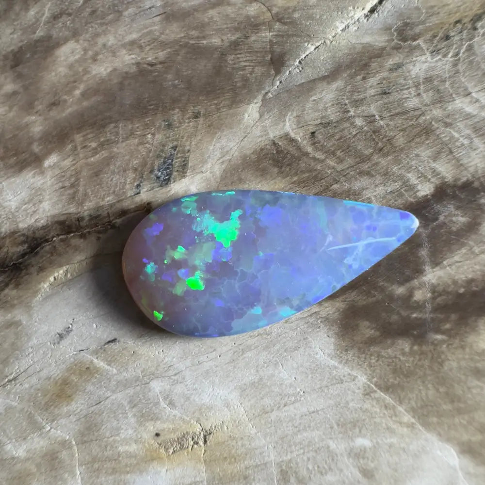 Teardrop-shaped opal with green and blue flashes.