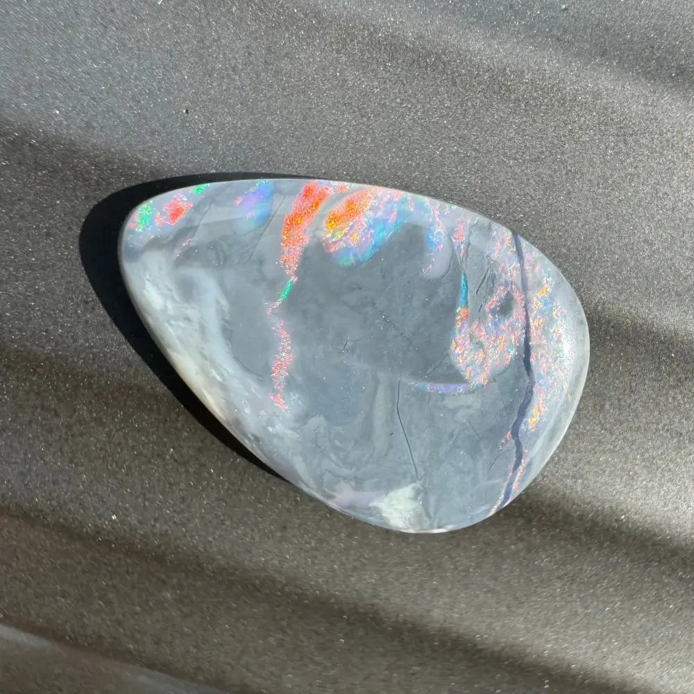 Iridescent gray opal cabochon from Lightning Ridge in a 5.7 carat hand-cut semi black opal