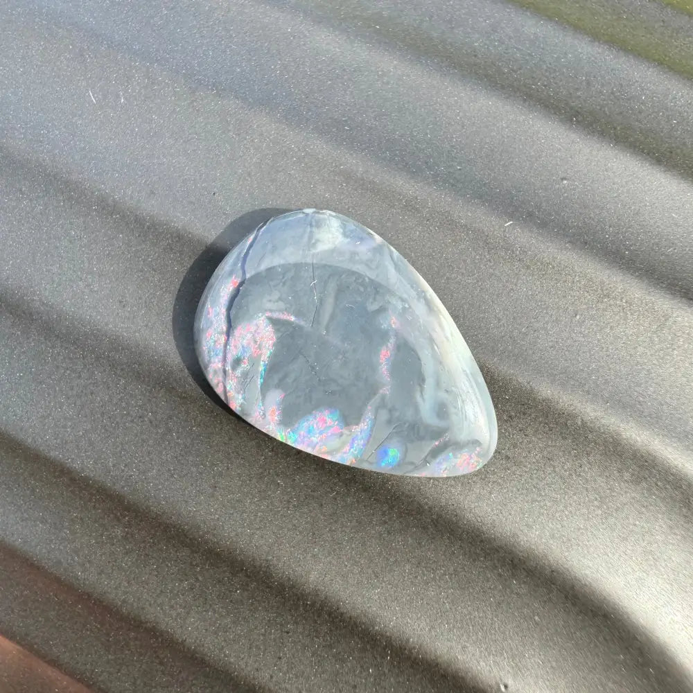 Iridescent gray teardrop-shaped stone in the 5.7 carat Hand-Cut Solid Lightning Ridge Semi Black Opal