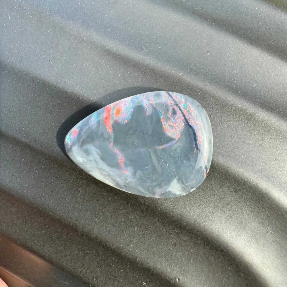 Iridescent teardrop-shaped opal in a 5.7 carat hand-cut Lightning Ridge semi black opal