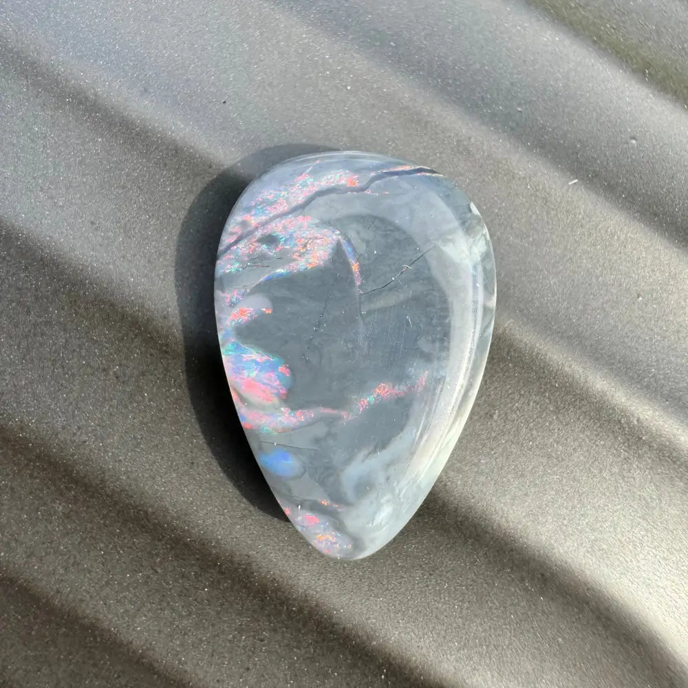 Teardrop-shaped Lightning Ridge semi-black opal with iridescent flashes in a 5.7 carat cabochon
