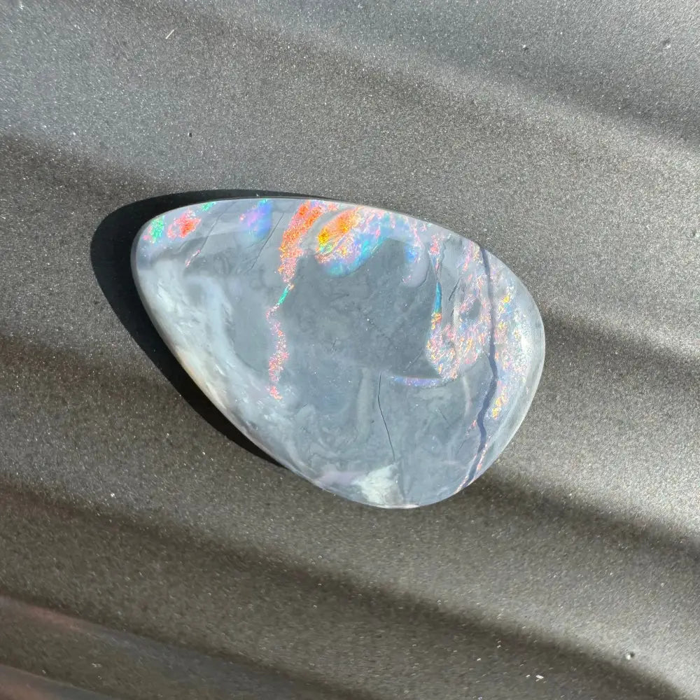 Iridéscent gray opal cabochon from Lightning Ridge in a 5.7 carat hand-cut semi black opal