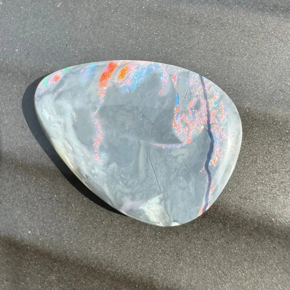 Irregularly shaped 5.7 carat Hand-Cut Solid Lightning Ridge Semi Black Opal with colorful flashes