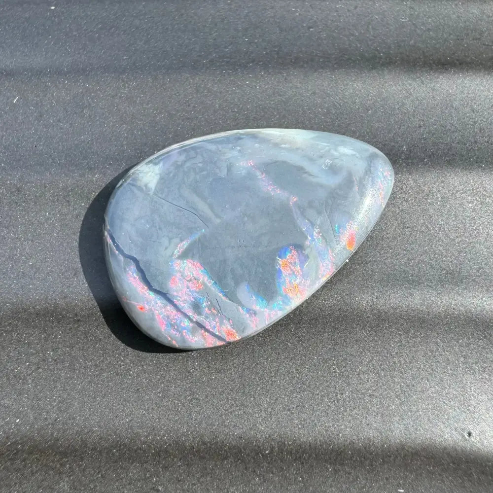 Polished gray stone with iridescent patches from 5.7 Carat Hand-Cut Lightning Ridge Semi Black Opal