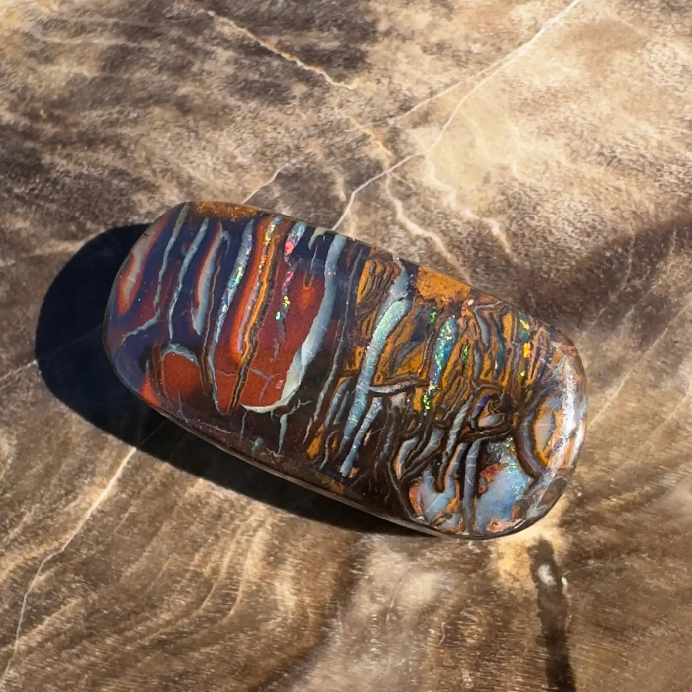 Polished Boulder Opal displaying vibrant color play for the 8.3ct Hand-Cut Solid Boulder Opal product