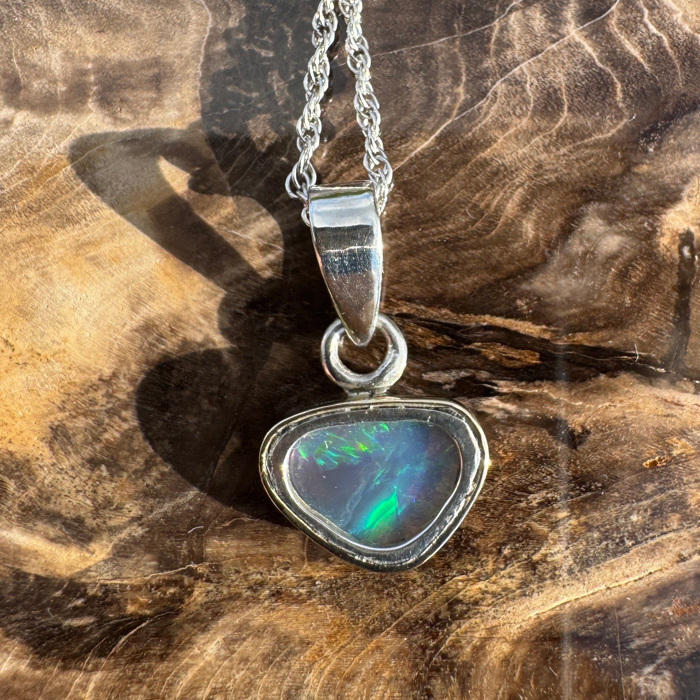 Opal pendant necklace on a wooden surface