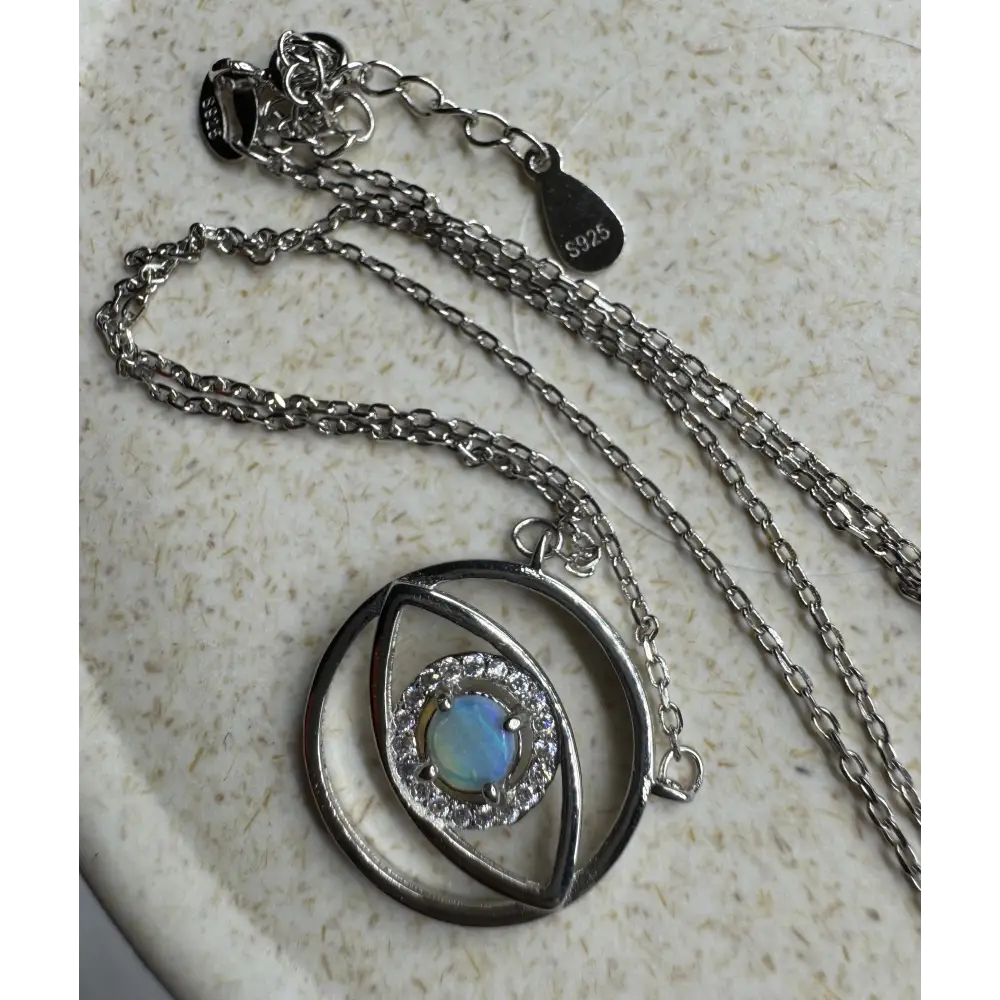 Silver necklace featuring a blue opal and diamond pendant from Lightning Ridge setting