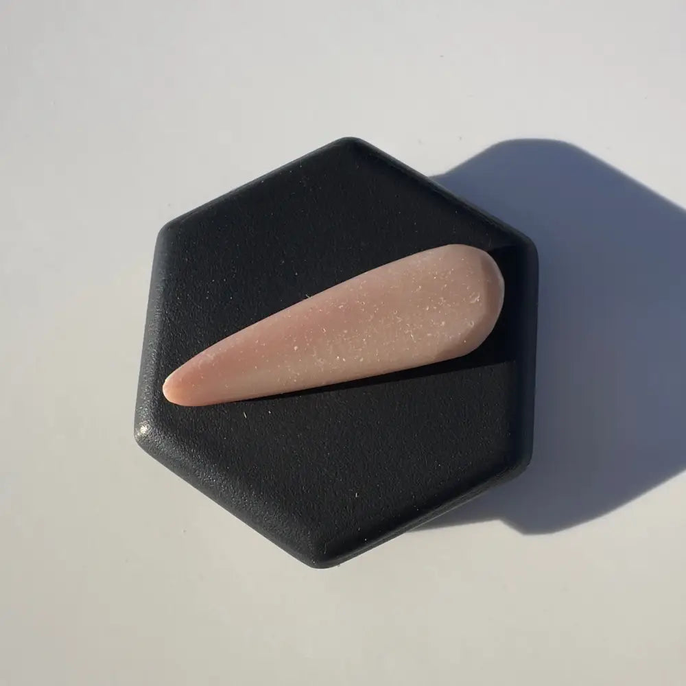 Pink glittery nail tip next to Coober Pedy Opal 2.6 carat solid hand-cut gemstone