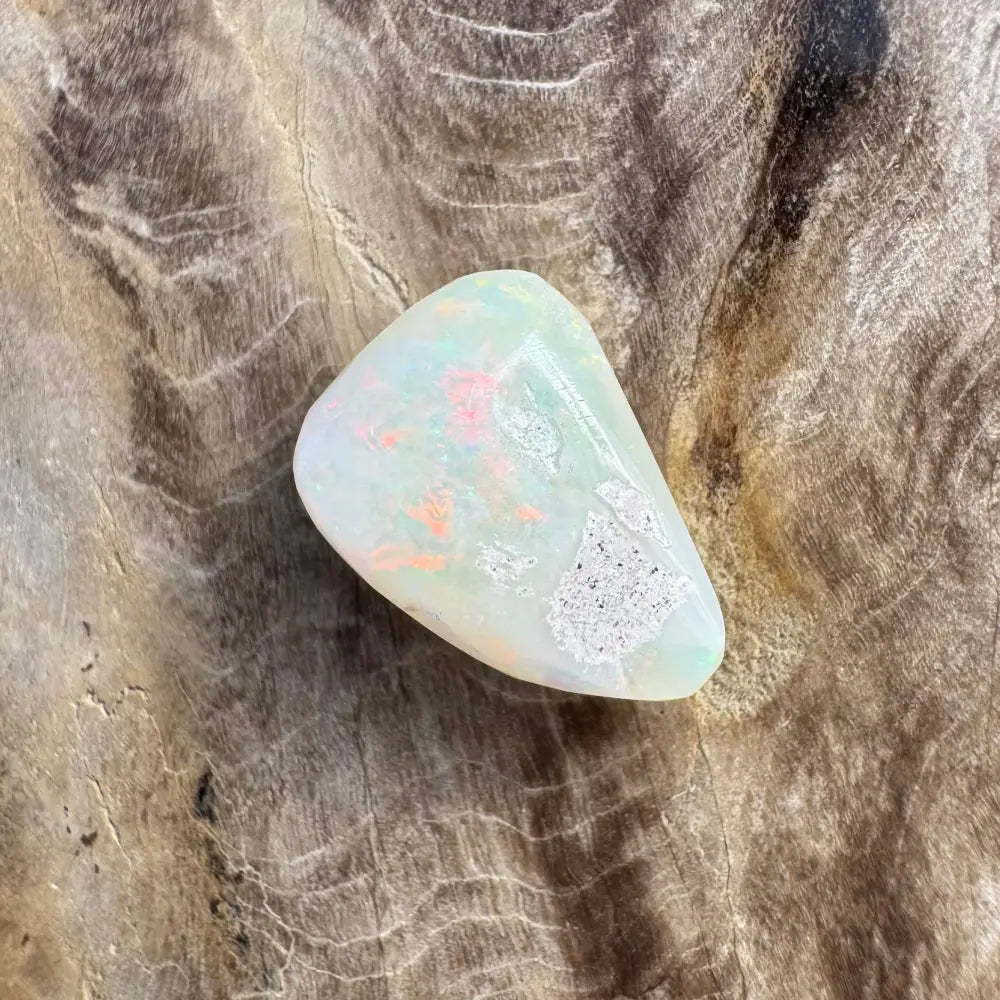 Polished white Coober Pedy opal with vibrant colorful flashes and hand-cut craftsmanship