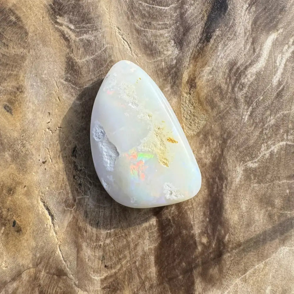 Polished white Coober Pedy opal with iridescent flashes and 8.4 carats in weight