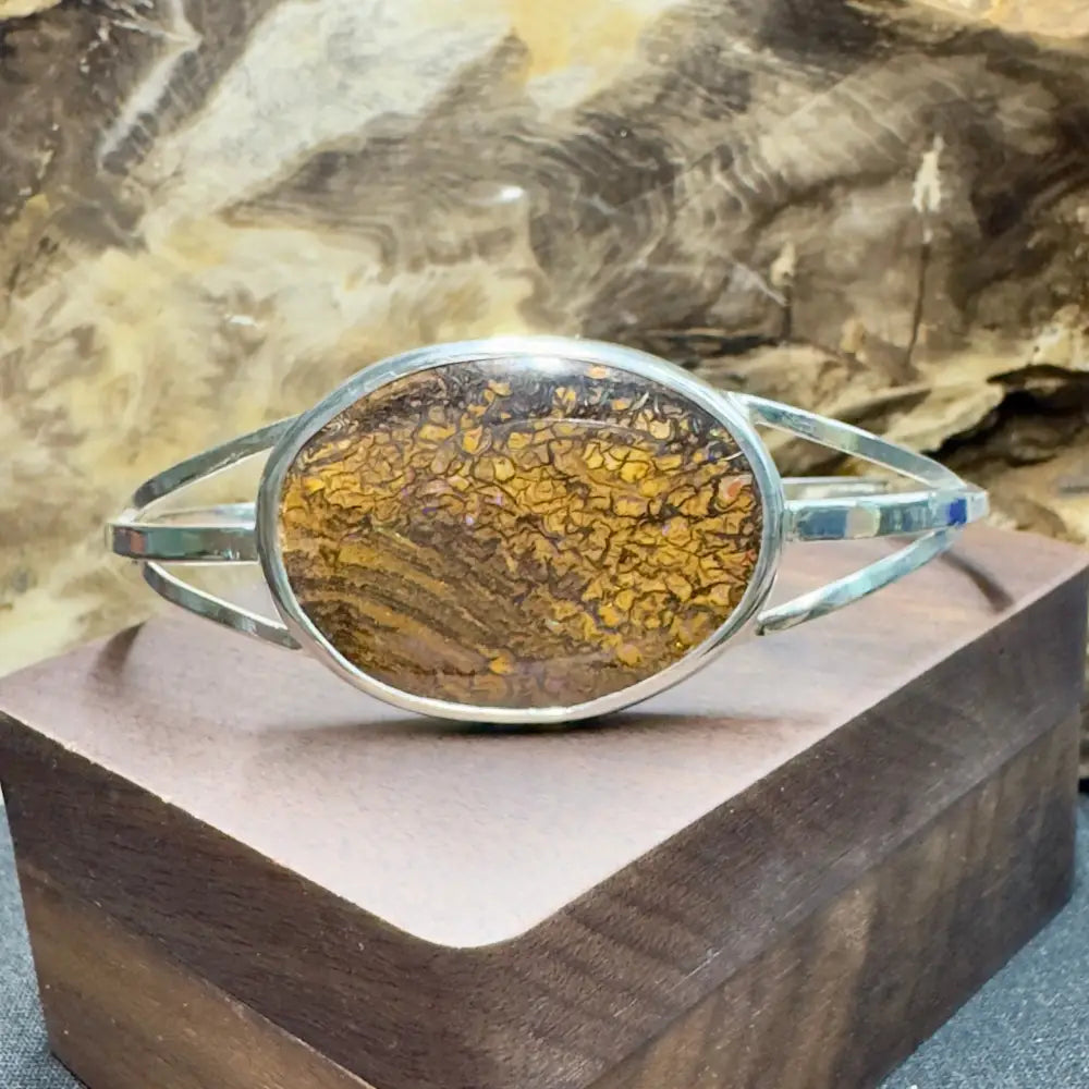 Silver bracelet with oval, brown and gold patterned stone.