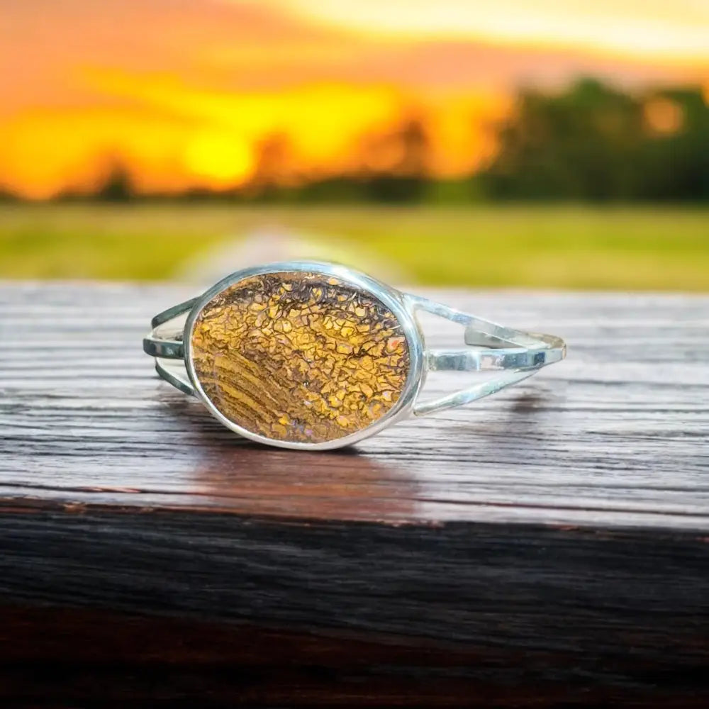 Silver bracelet with golden stone.