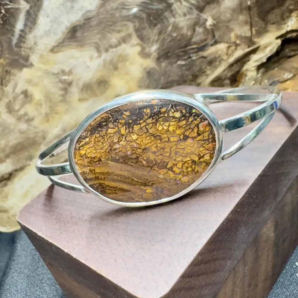 Silver bracelet with an oval, brown and yellow patterned stone.