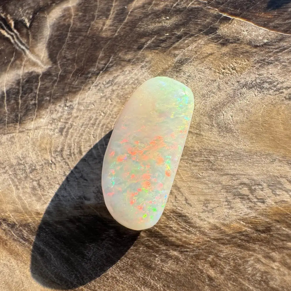Hand-cut solid Coober Pedy opal with iridescent play of colors in a 2.9 carat cabochon
