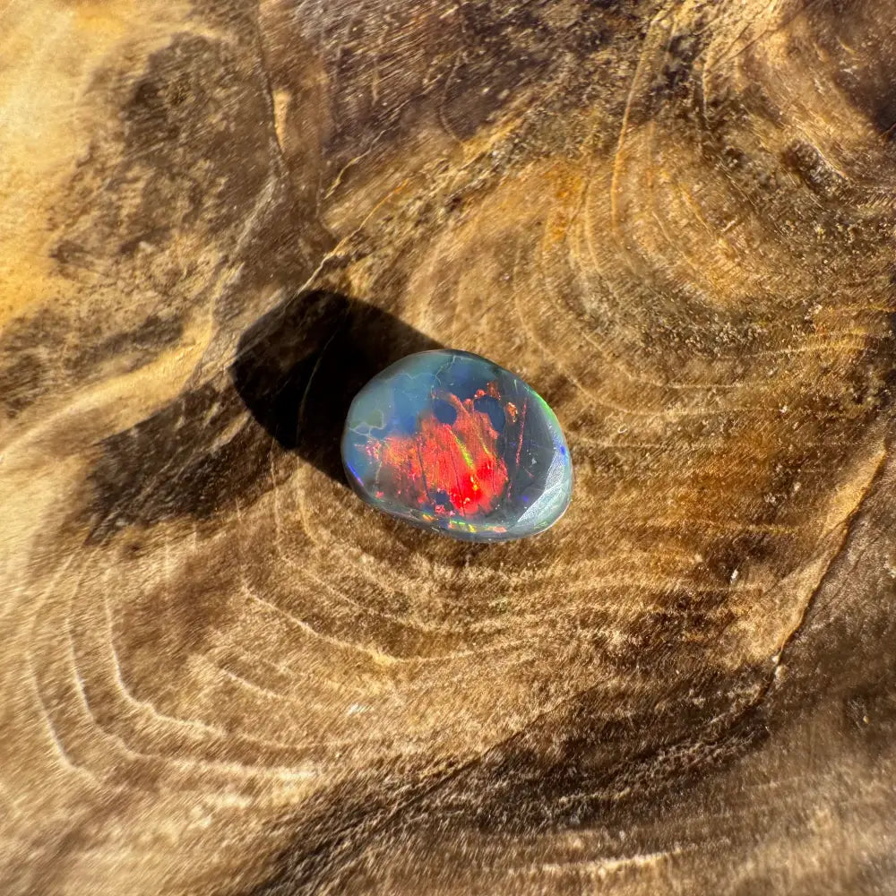 Iridescent opal gemstone in a hand-cut Lightning Ridge Black Opal 0.9 carat product
