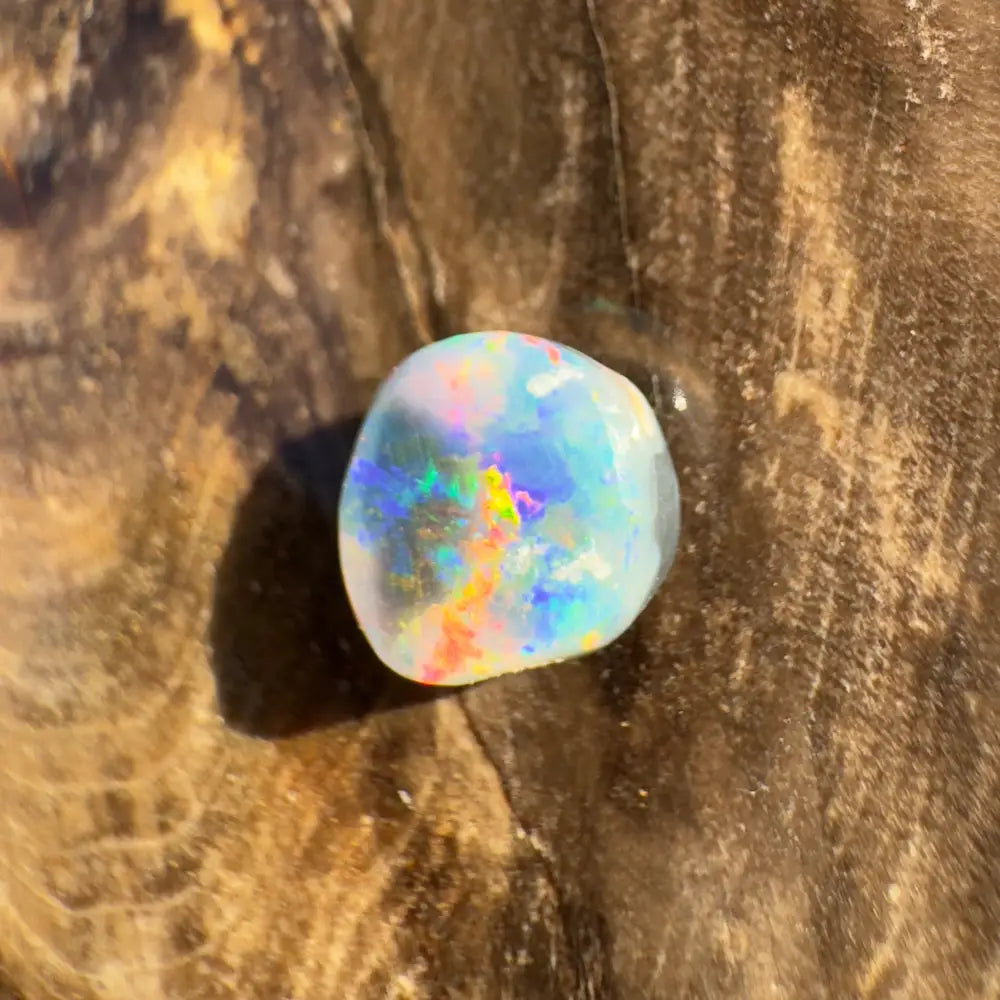 Iridescent Lightning Ridge Black Opal gemstone in a hand-cut 0.9 carat product display