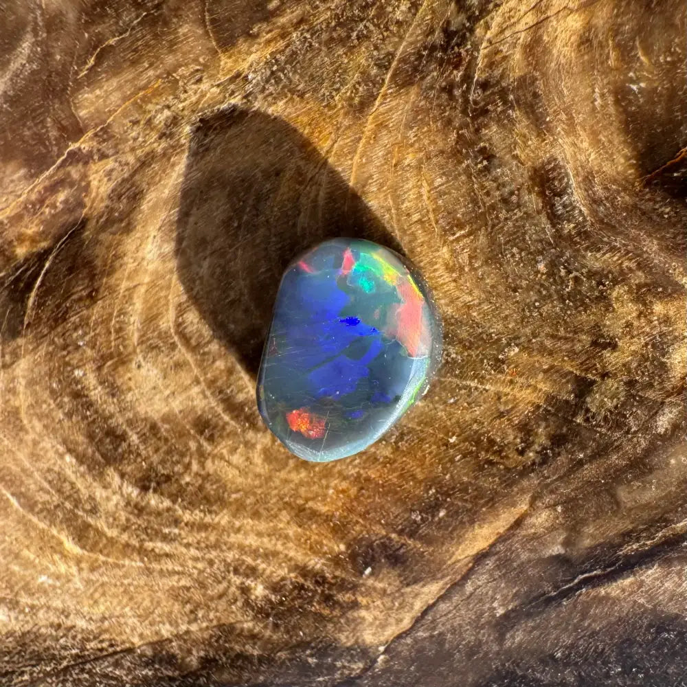 Iridescent black opal gemstone from Lightning Ridge in a 0.9-carat hand-cut solid setting