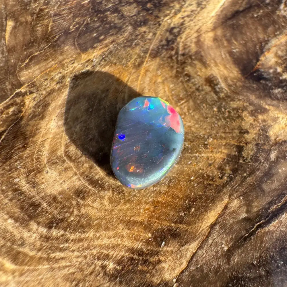 Hand-cut Solid Lightning Ridge Black Opal 0.9carat showcasing an iridescent opal gemstone