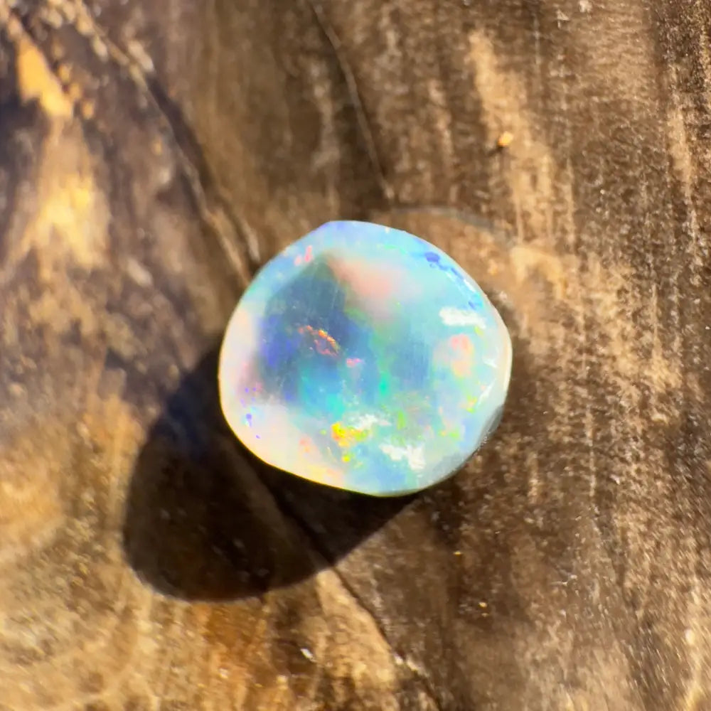 Iridescent opal gemstone displayed in a hand-cut solid Lightning Ridge Black Opal 0.9 carats