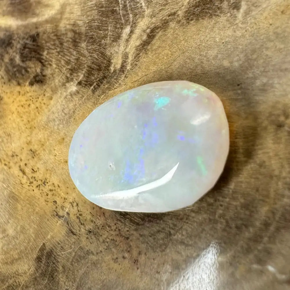 Iridescent white opal cabochon displayed on hand-cut Solid Lightning Ridge Opal 1.2 carat