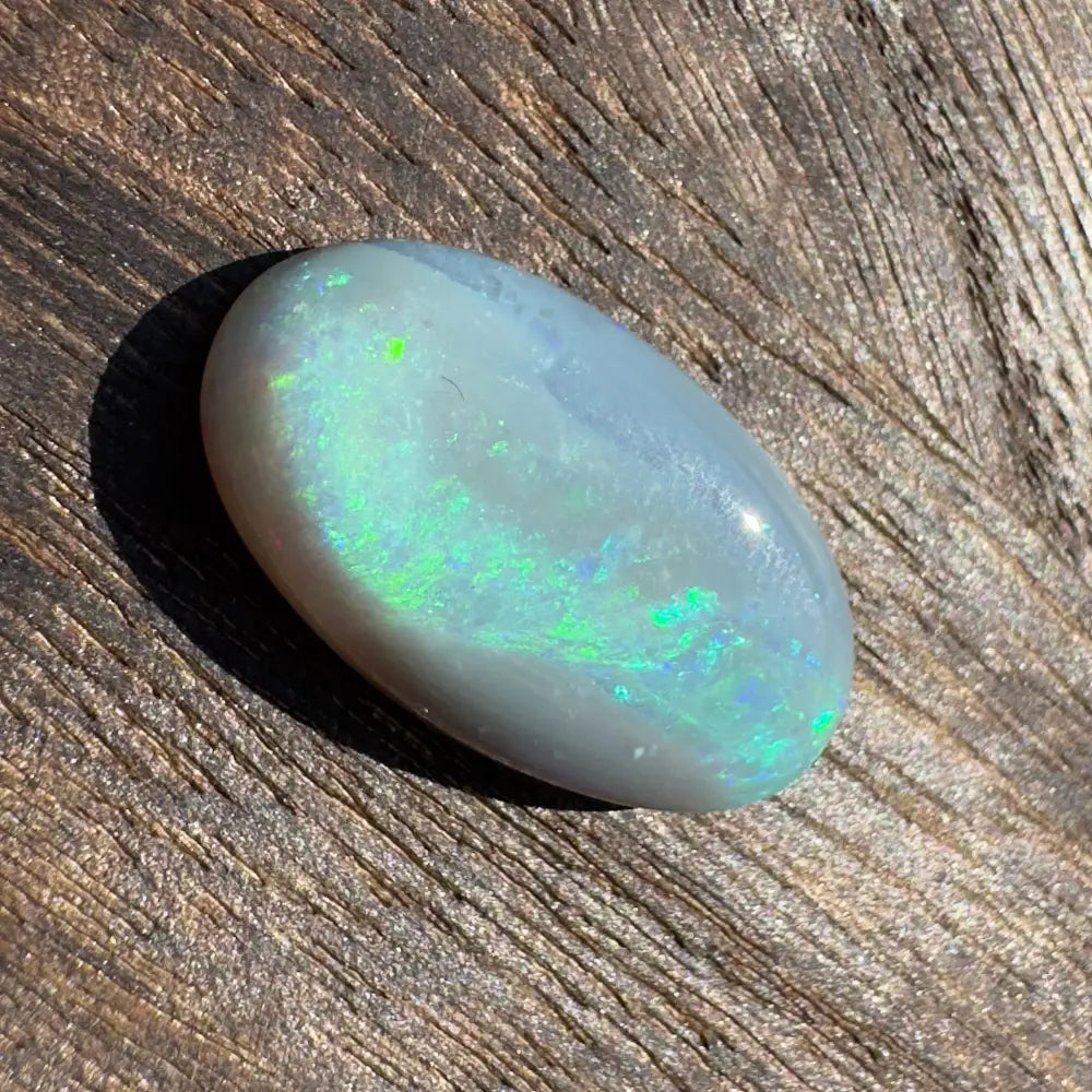 Oval opal cabochon with vibrant green play-of-color in a Hand-Cut Solid Lightning Ridge Opal 11.6 carat